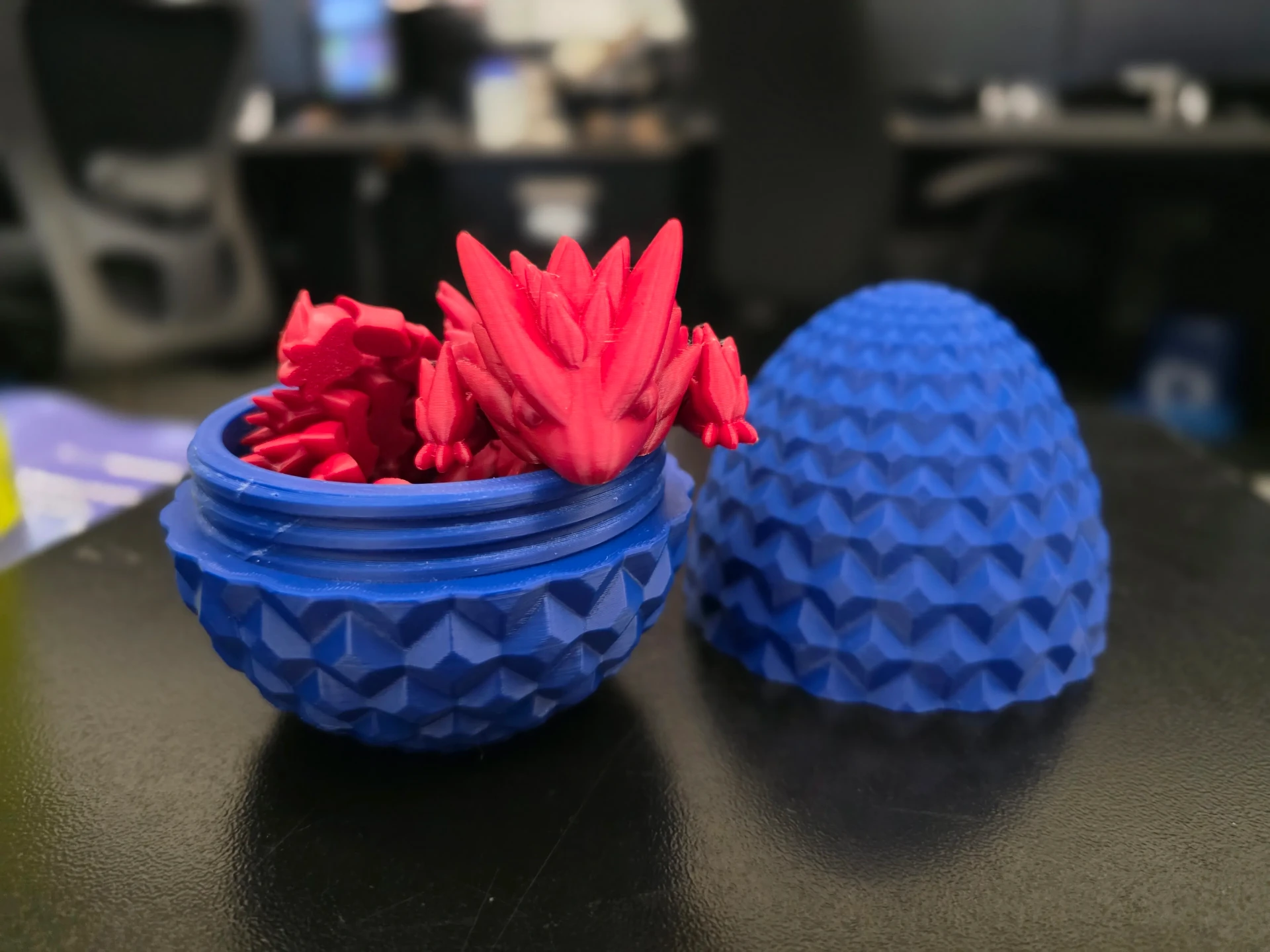 Blue textured egg case opened to show a red articulated dragon